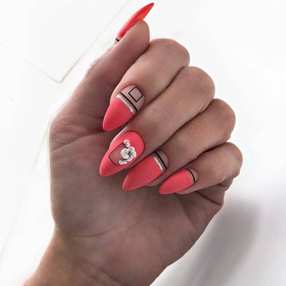 Stiletto nails in bright red with geometrical shapes and negative space