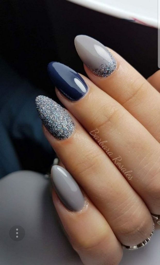 Deep blue polish in combination with gray and shimmer on almond shaped nails