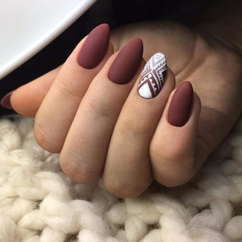 Maroon nails with a white pattern on  the ring fingernail 