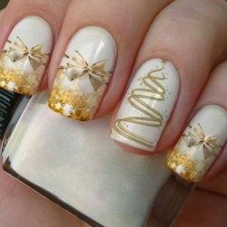 gold bow and christmas tree stickers on white nail polish coat