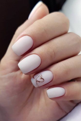 Gold heart outline on accent nail on white polish