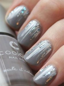 Sparkly white and silver polish strokes from nail bed