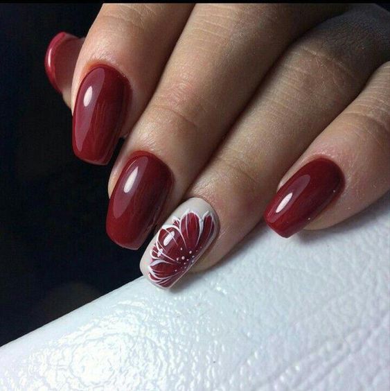 Red nails with red flower nail art on accent nail