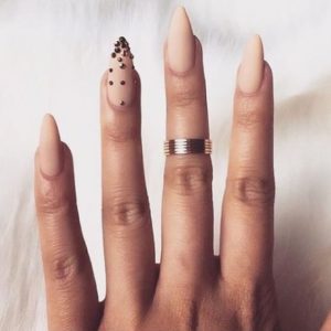 Almond-shaped nude nails with golden dots