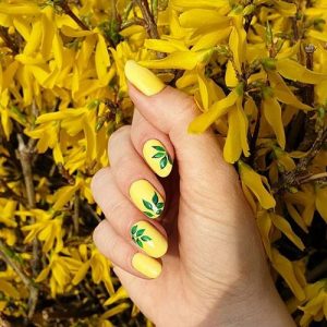 nail art of leaves on yellow nails